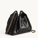 Diamant black quilted leather drawstring bucket bag with antique gold chain straps – side view