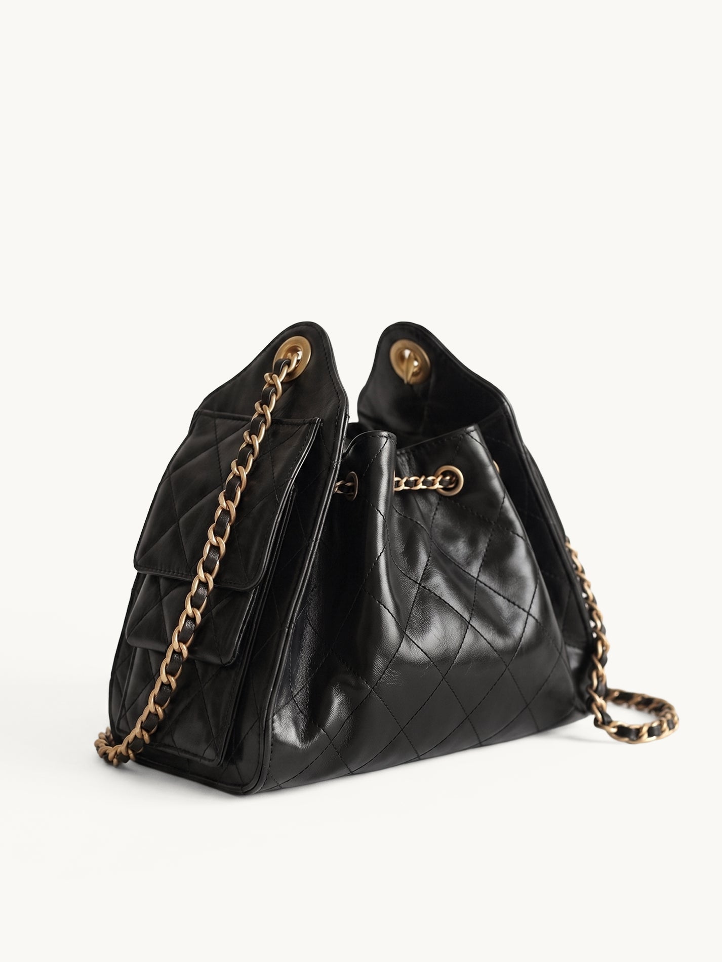 Diamant black quilted leather drawstring bucket bag with antique gold chain straps – side view